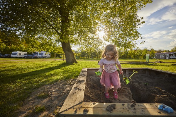 Meisje in zandbak op de camping