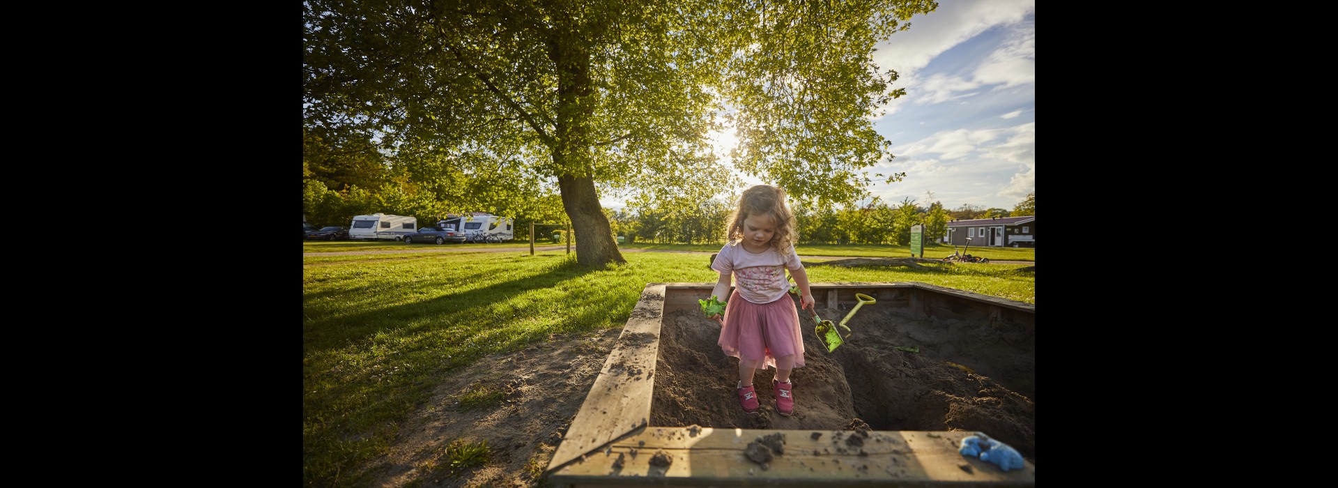 Meisje in zandbak op de camping